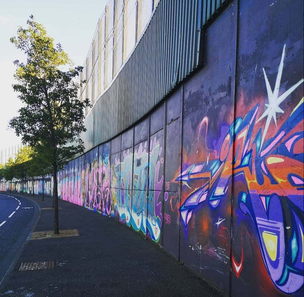 Walk the Peace Wall and International Wall of Murals. 