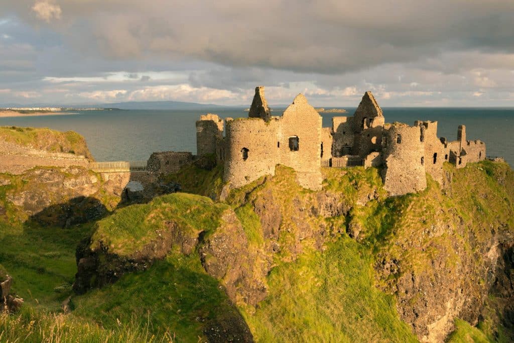 Watch the sun go down over Dunluce Castle on your Ireland road trip itinerary.