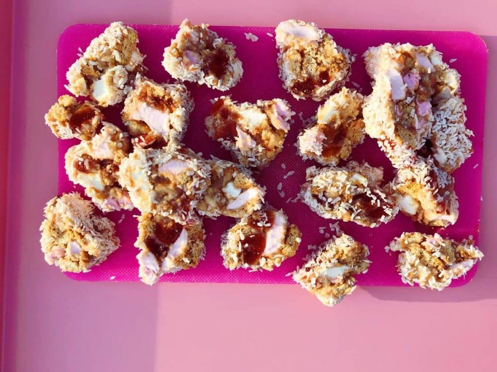A shot of Northern Irish sweet treat, fifteens atop a pink chopping board.