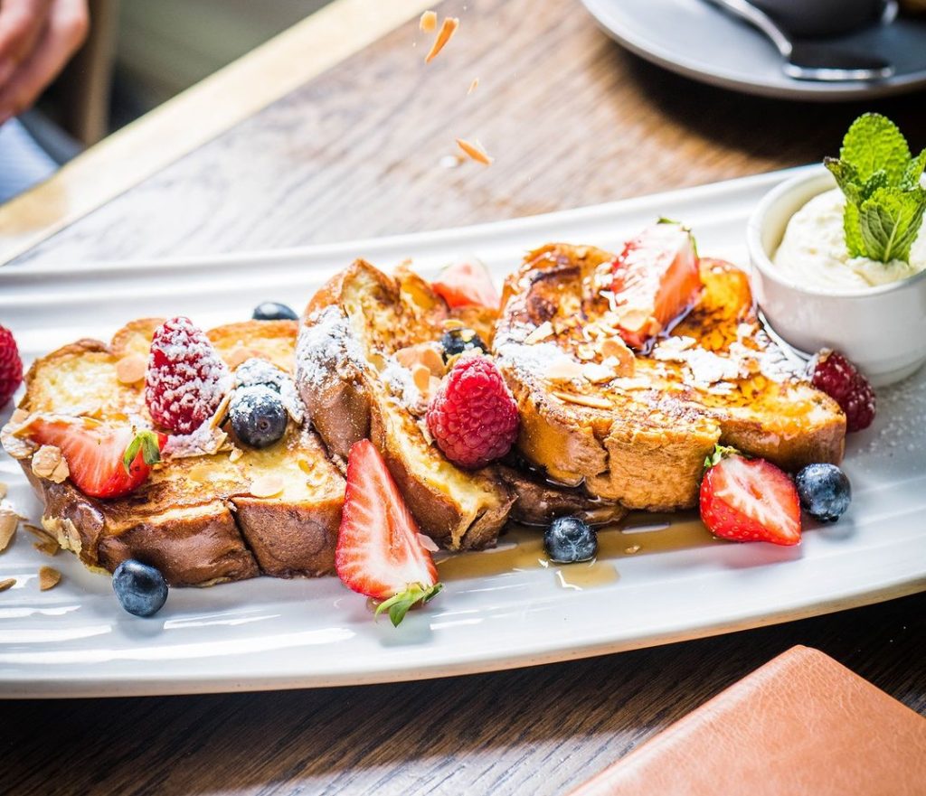 A delectable serving of French Toast Mix topped with seasonal berries and Chantilly cream, served at The Spitjack, one of Cork’s must-visit foodie destinations, enticing with its irresistible combination of flavors and textures.