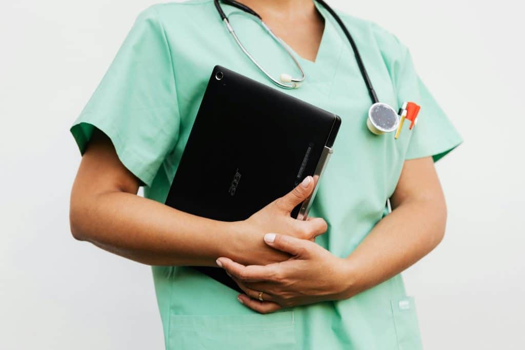 A doctor holding a laptop.