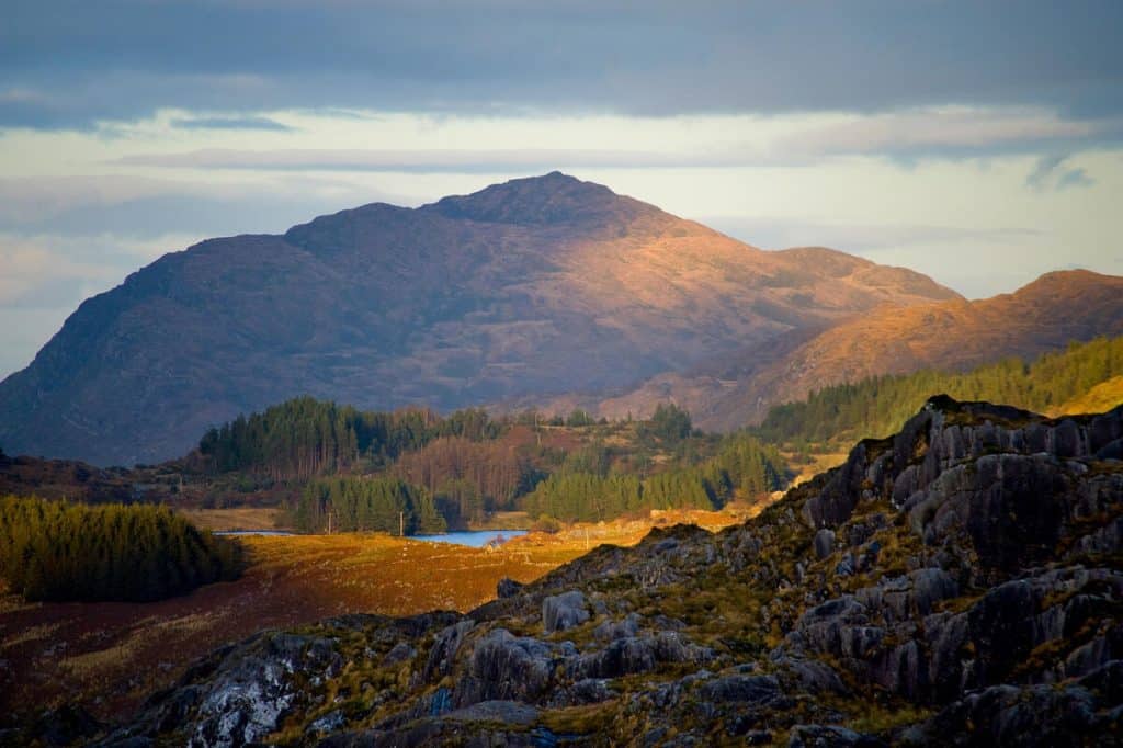 Landscape of the Ring of Kerry with Torc Mountain behind Looscauragh Lough, on a sunny, slightly cloudy day.