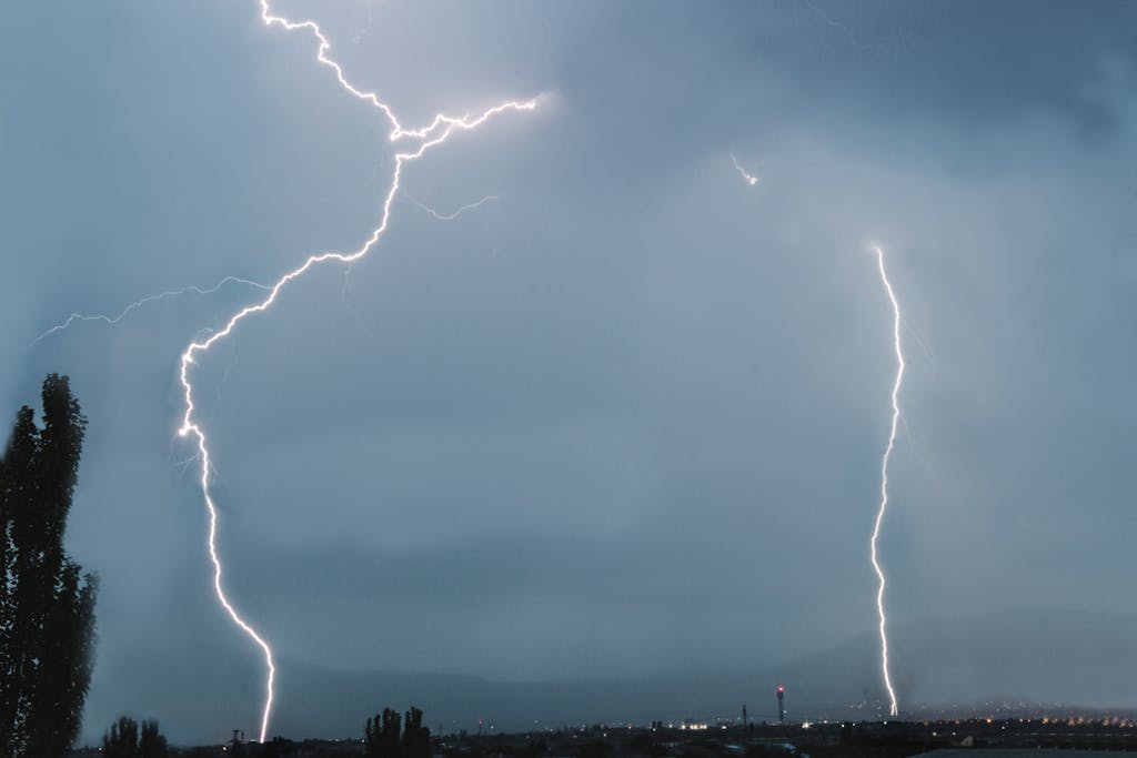 Stunning capture of a lightning storm illuminating an urban skyline at night.