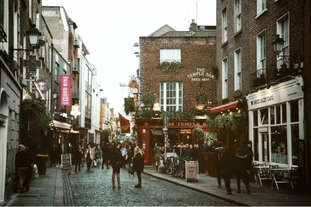 View of the Temple Bar bar in the Temple bar district, with people walking down the street.