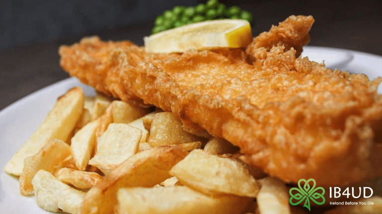 Fish and chips with a lemon slice and peas.