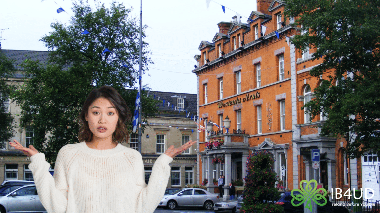Woman gesturing in front of the historic Western Arms hotel building in Monaghan.